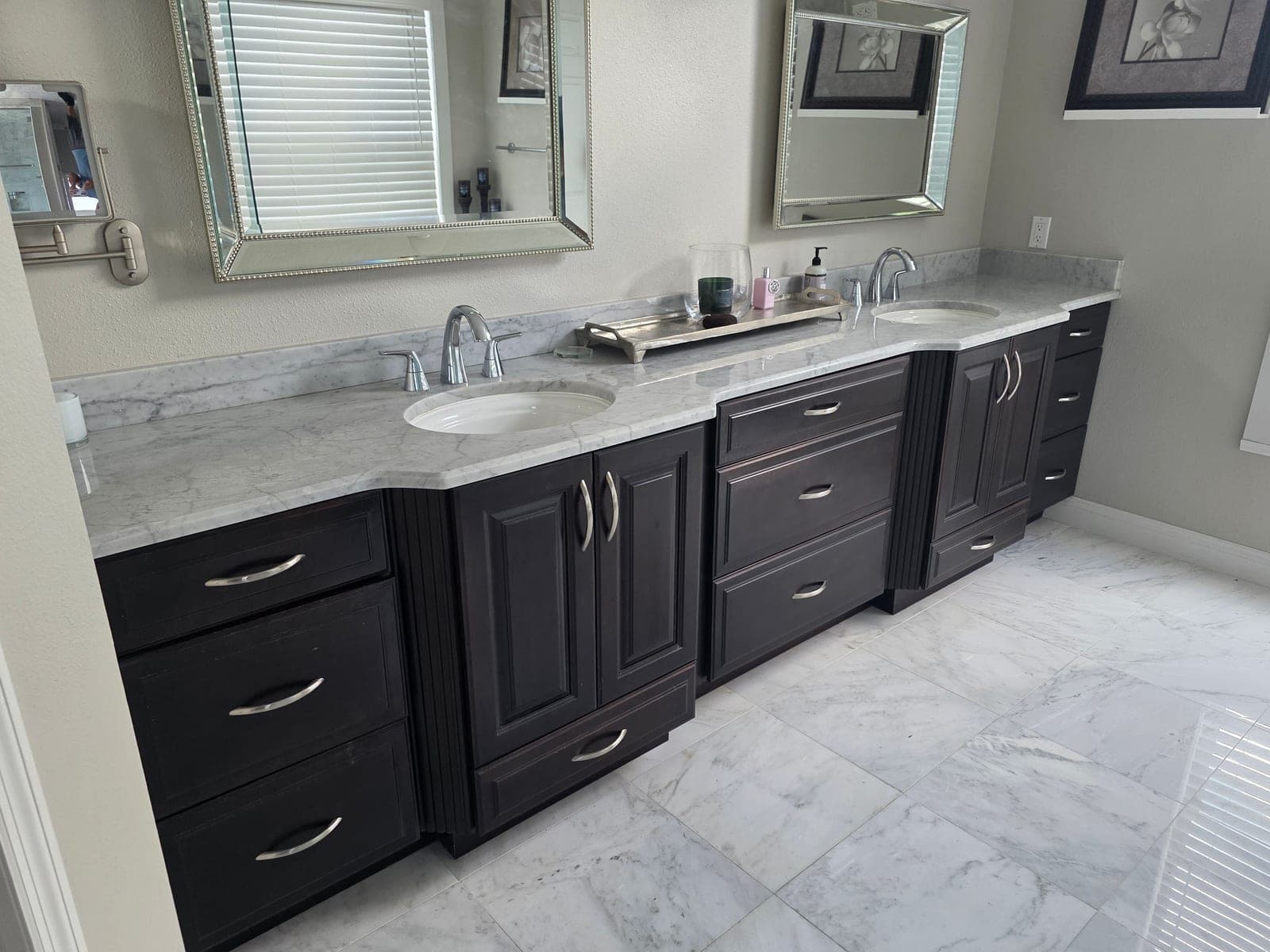 Espresso double vanity with marble countertops, undermount sinks, and marble tile floor