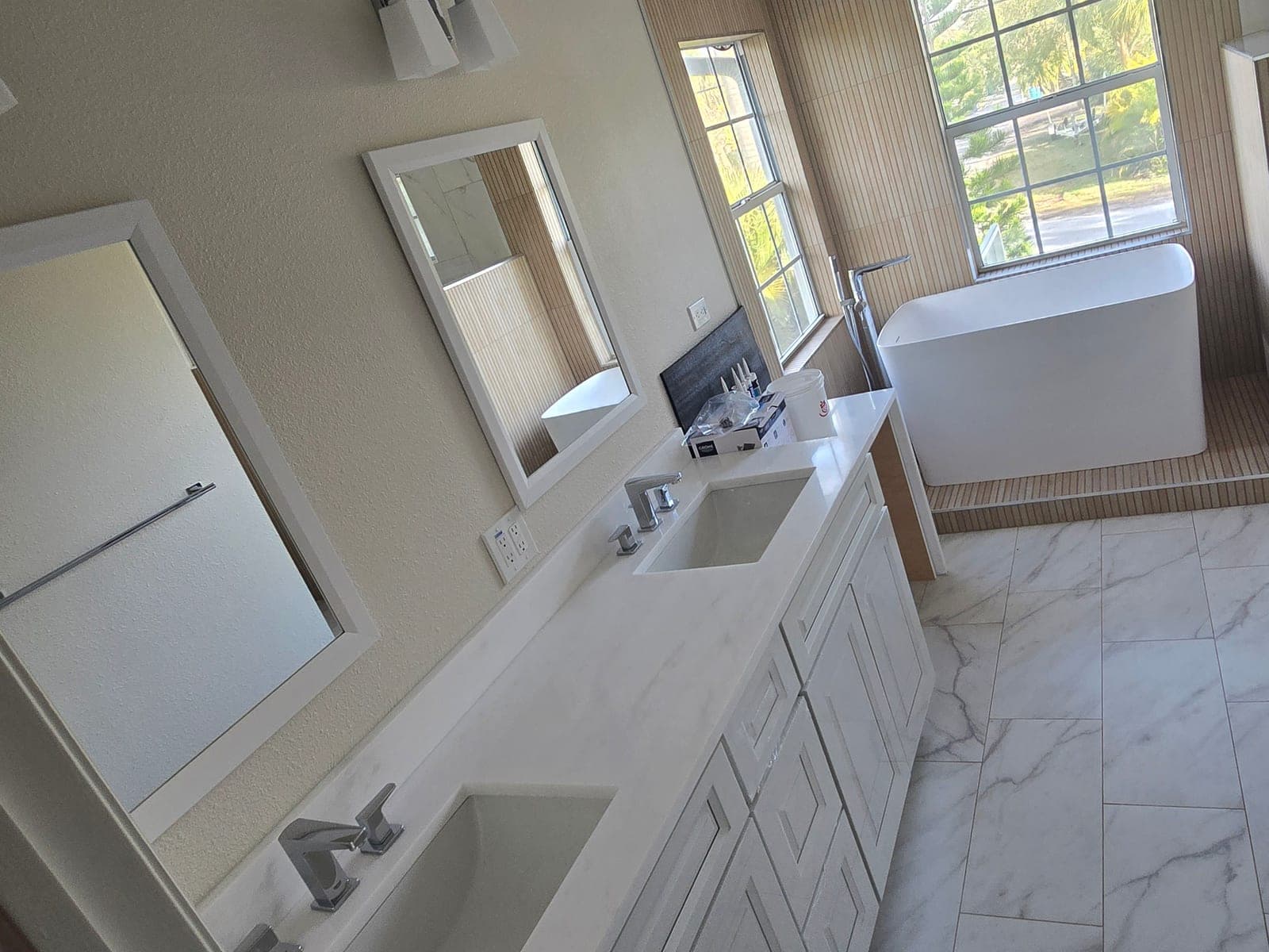 Double vanity with quartz countertop looking toward the freestanding tub