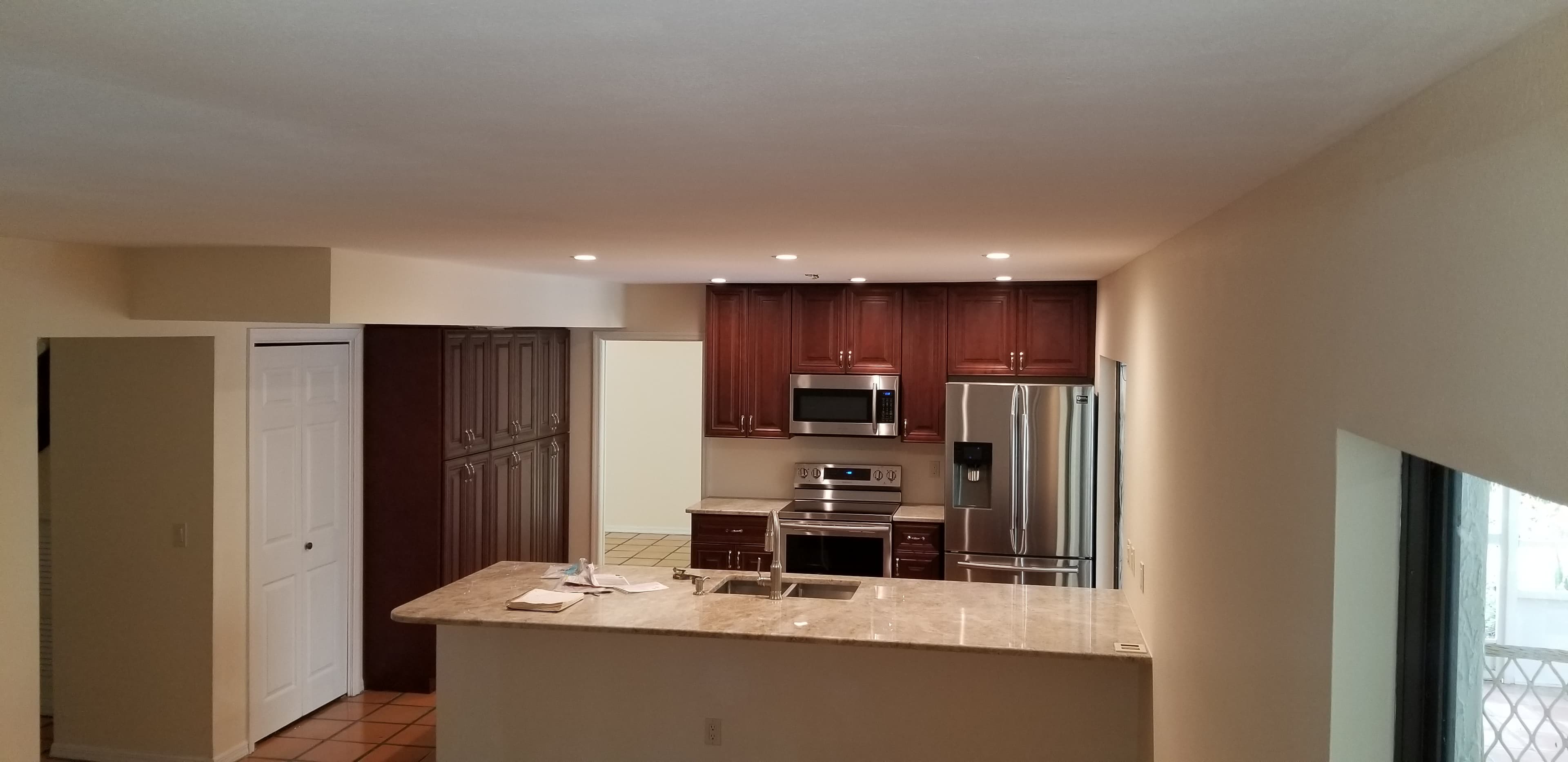 Kitchen remodel with cherry raised panel cabinets, granite island, stainless appliances, and recessed lighting