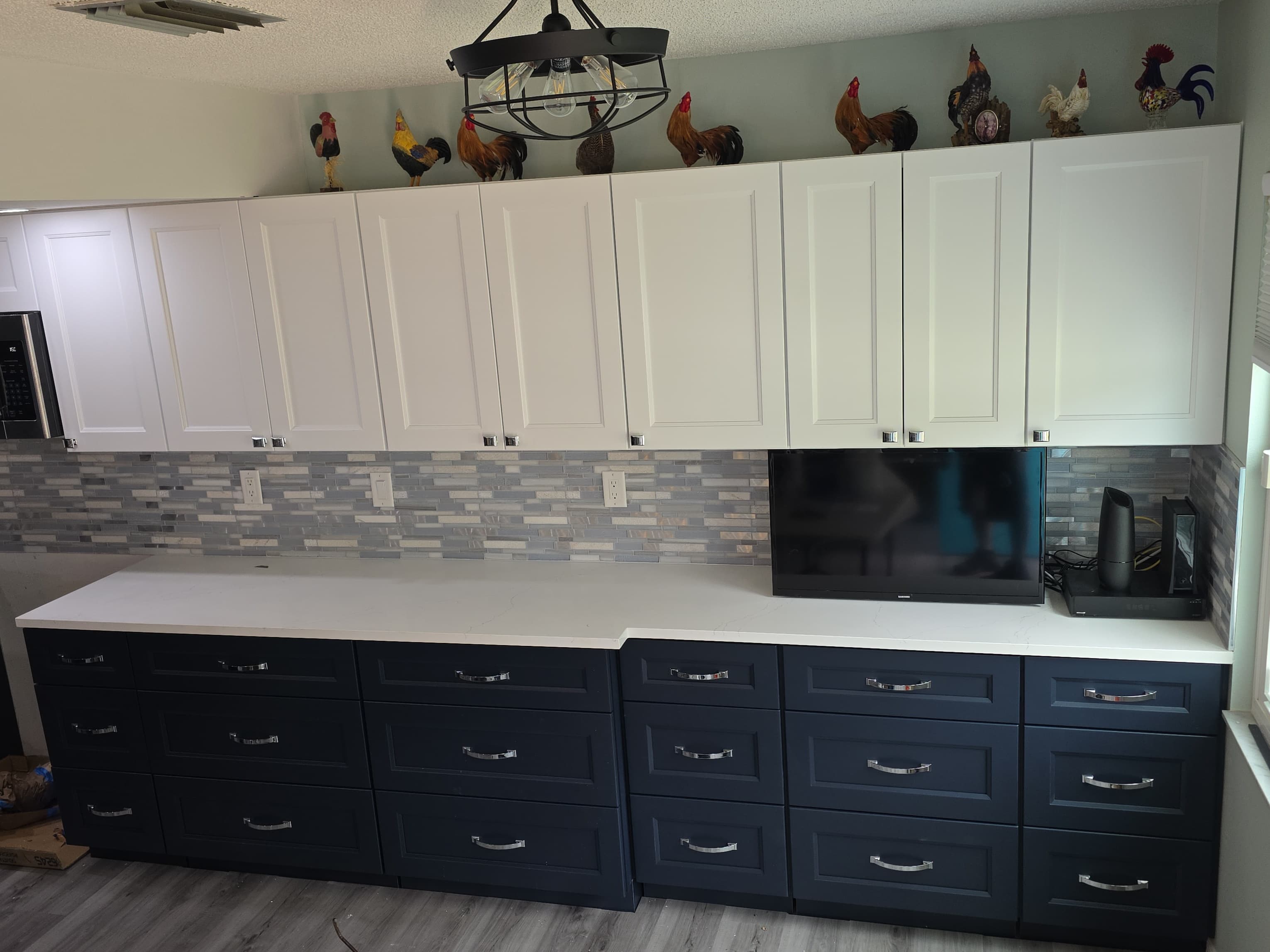 Completed two tone kitchen with navy cabinets, white uppers, and quartz countertops