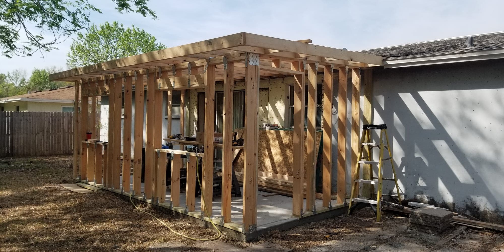 Room addition framed off the back of an existing house with rafters in place